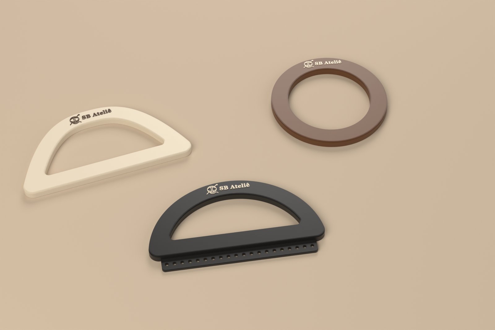 Três alças para bolsa de crochê impressas em 3D com o logo SB Ateliê: arco natural, argola marrom e meia-lua preta com aba de furos